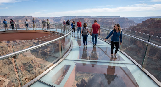 Visitors walking on glass skywalk over deep canyon