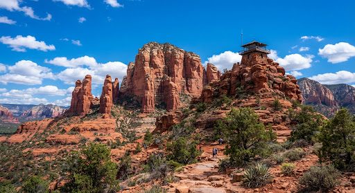 Towering red rock formations and mountain lookout tower against vibrant blue sky